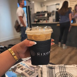 a person holding an iced coffee