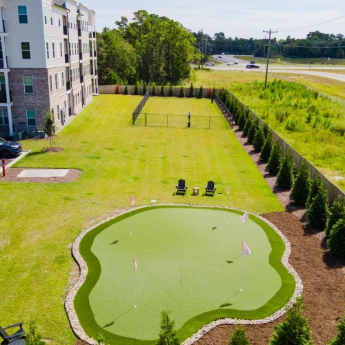 a large green field with a building in the background